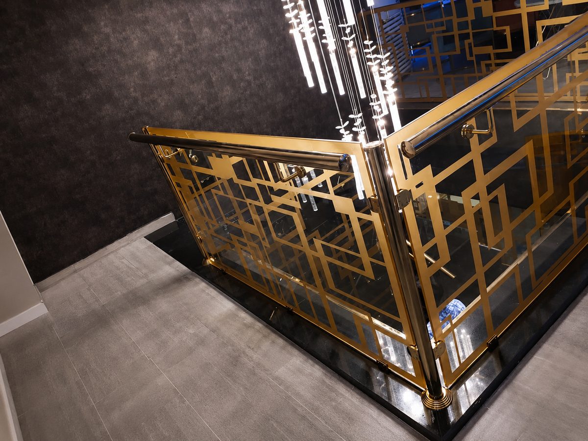 Gold laser-cut decorative panel balustrade with a polished brass handrail