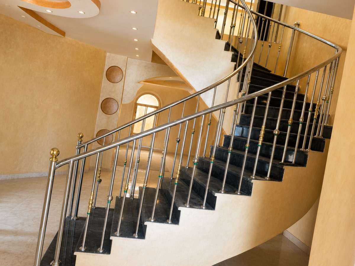 Curved stainless steel and brass staircase railing