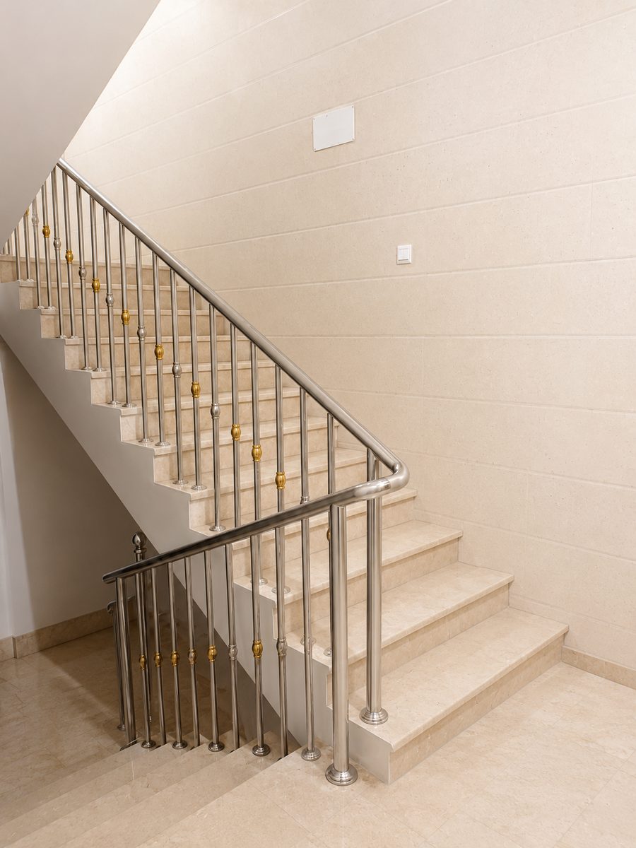 Brushed stainless steel staircase railing on marble steps